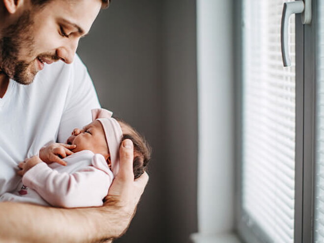 Papá alzando su bebé y revisando los granito de su cara