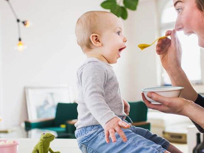 Mamá alimentando a su hijo con una papilla