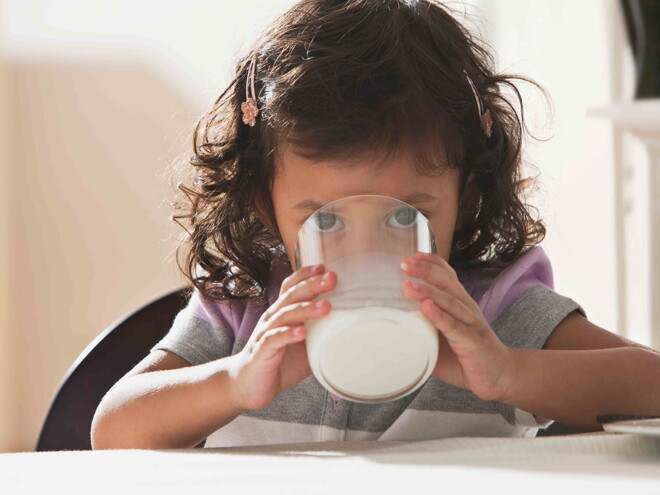 Niña pequeña tomando leche.