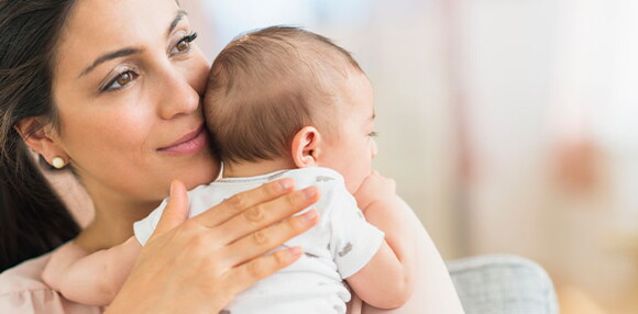 Mamá alzando a su bebé de tres meses.