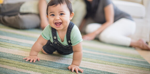 Bebé de 7 meses gateando en compañía de sus padres