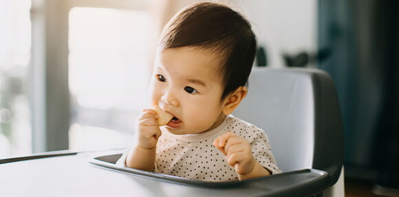 Niña comiendo galletas para bebés