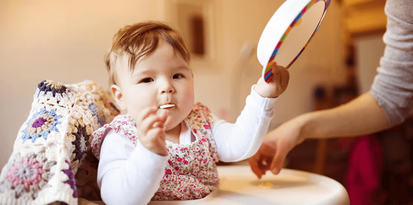 Un niño a la hora de comer con su plato en la mano