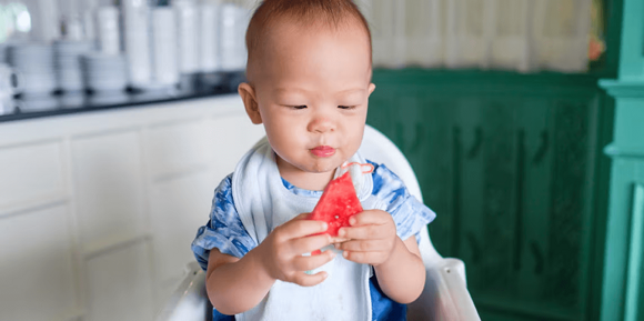 Niño sosteniendo un pedazo de sandía