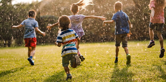 Niños corriendo en un parque.