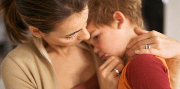 Mamá consolando a su hijo que está triste