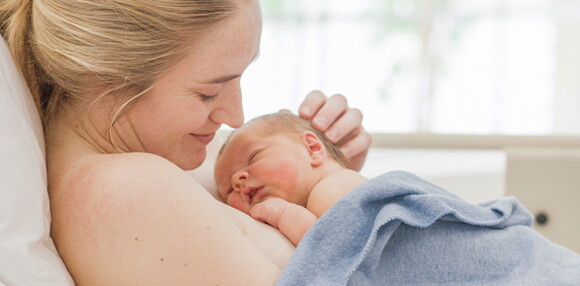 Mamá teniendo a luz a su bebé por parto inducido.