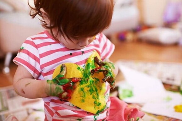 niña jugando con pintura