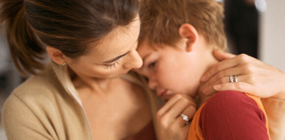 Mamá consolando a su hijo que está triste.