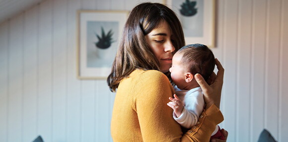 Mamá aliviando el hipo de su bebé recién nacido