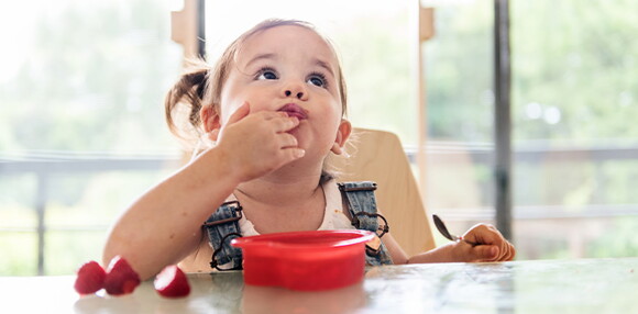 Niña comiendo frutilla.