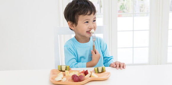 Niño contento consumiendo probióticos saludables